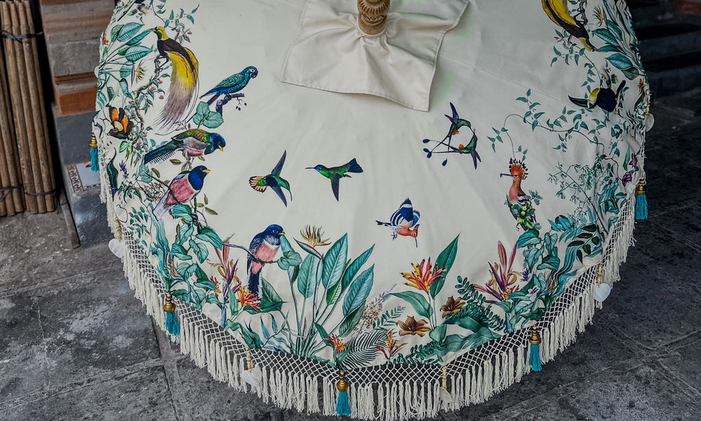 Modern Balinese parasol with printed fabric and macramé details, blending traditional design with contemporary outdoor style.