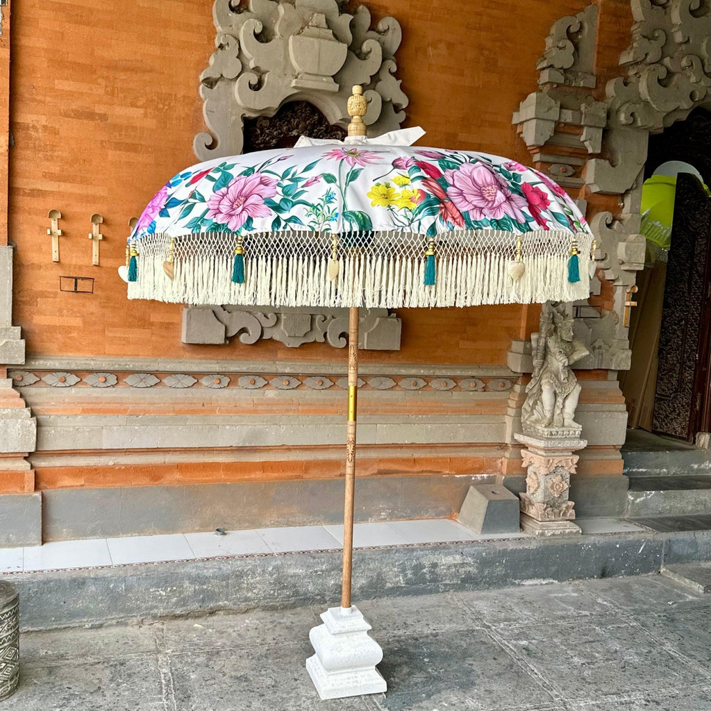 Side view of the Daisy Balinese Parasol on a hand-carved wooden pole, perfect for outdoor garden decor.