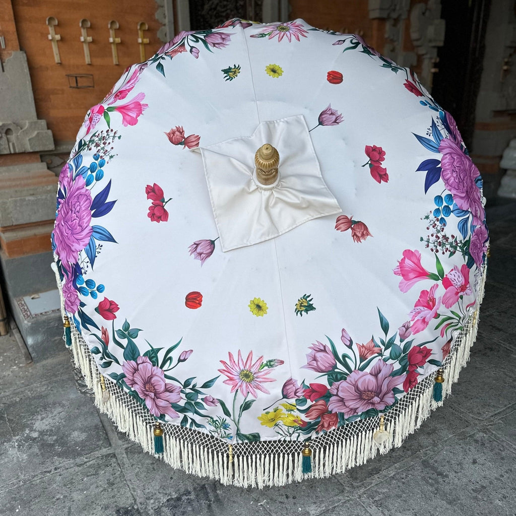 Daisy Parasol fully opened, showcasing vibrant floral prints on a white canvas with delicate fringe details.