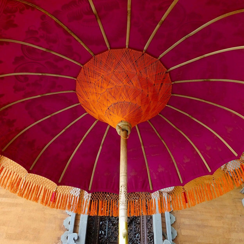 Underside view of Cecilia Parasol with orange inner threading and bamboo spokes supporting the structure.