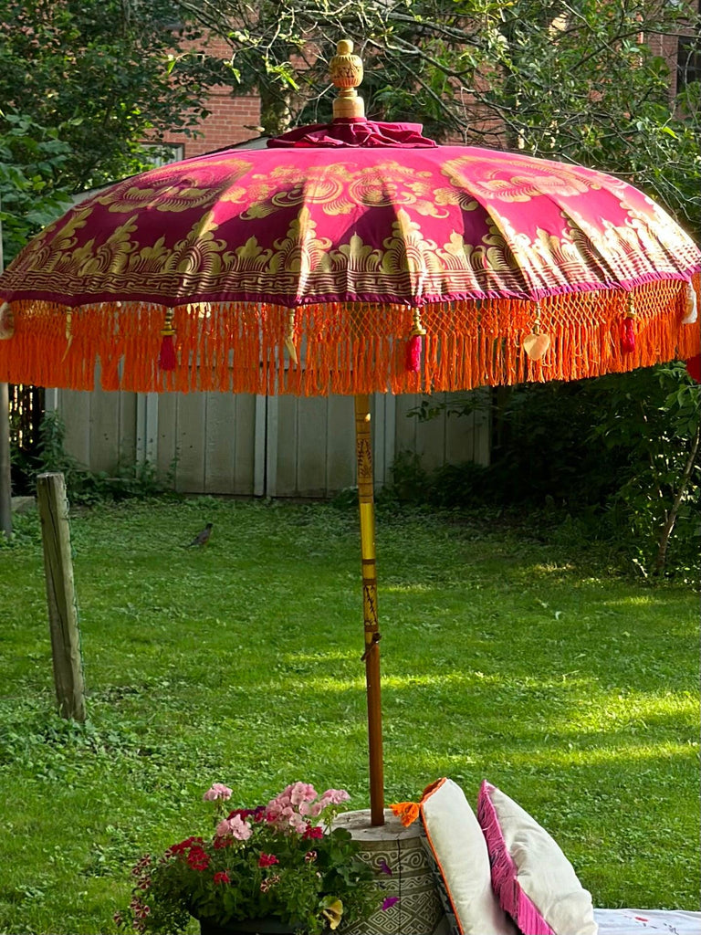 Top view of the Cecilia Parasol showcasing bold gold patterns on vibrant pink and purple fabric.