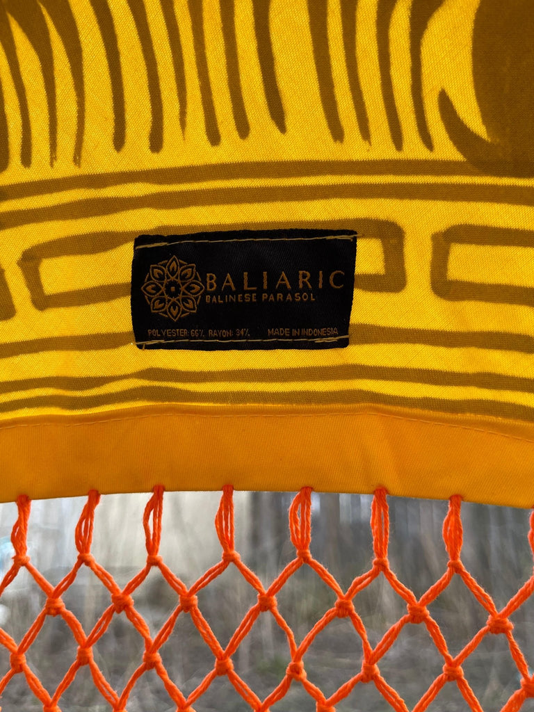 Detailed gold artwork on the Arabella Parasol, showcasing intricate craftsmanship on yellow fabric.