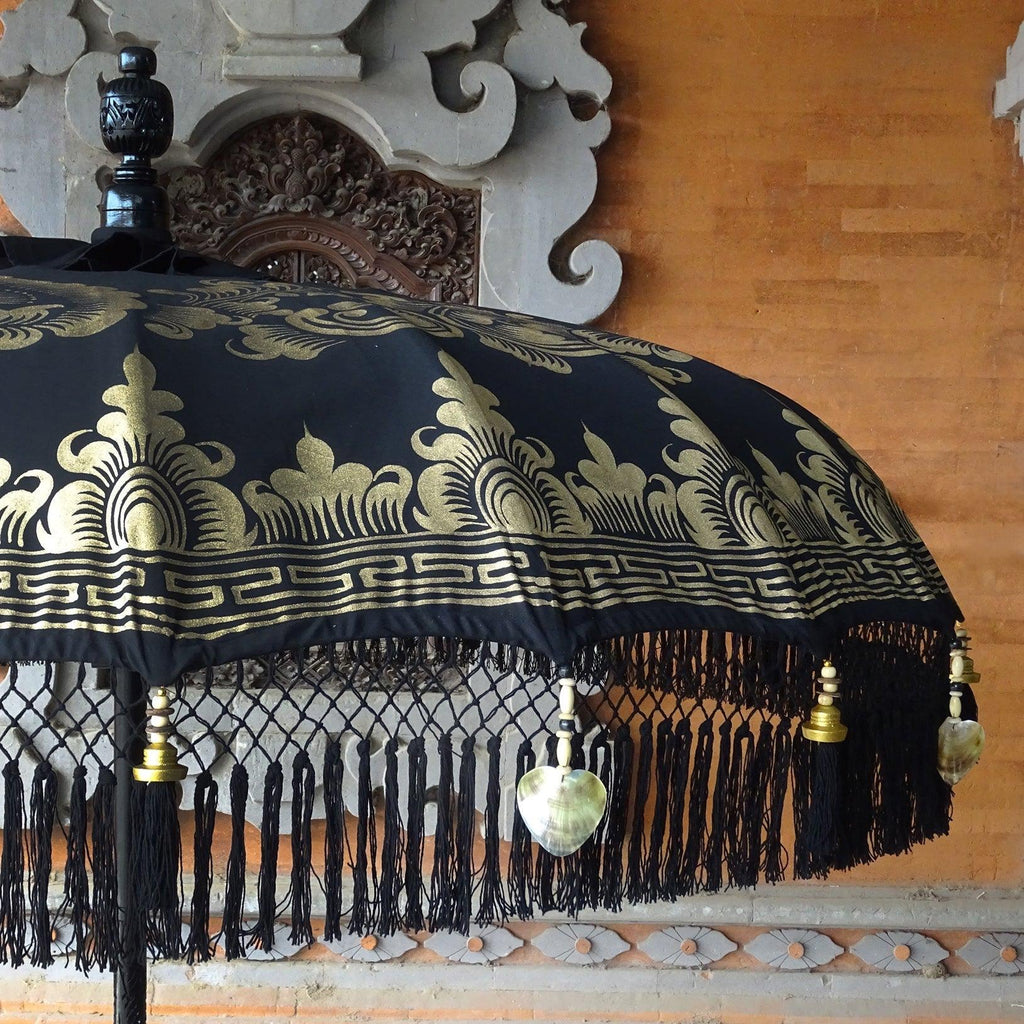 Top view of Carl Parasol showcasing gold artistic patterns on a deep black background.