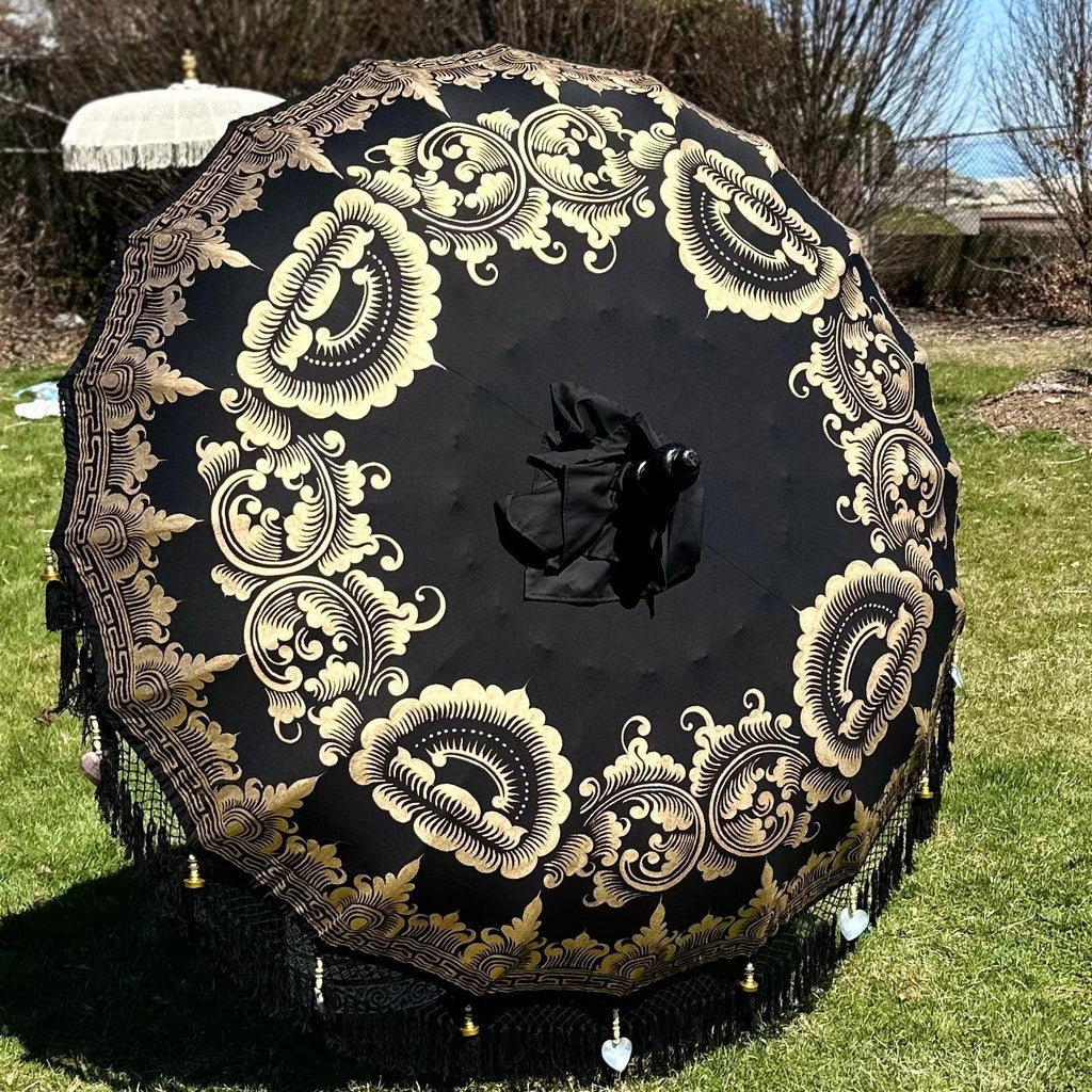 Carl Parasol adding a bold and luxurious touch to an outdoor garden space with its black and gold design.