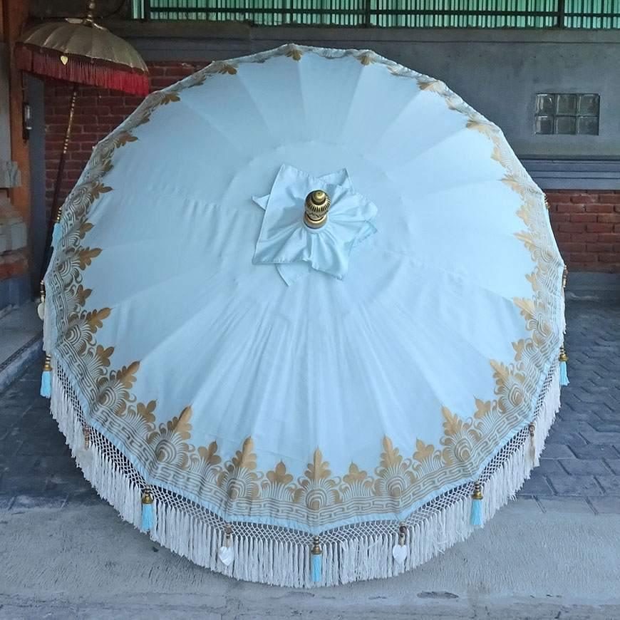 Light blue Baby Blue Parasol with gold accents and wooden pole, ideal for beach or garden décor.