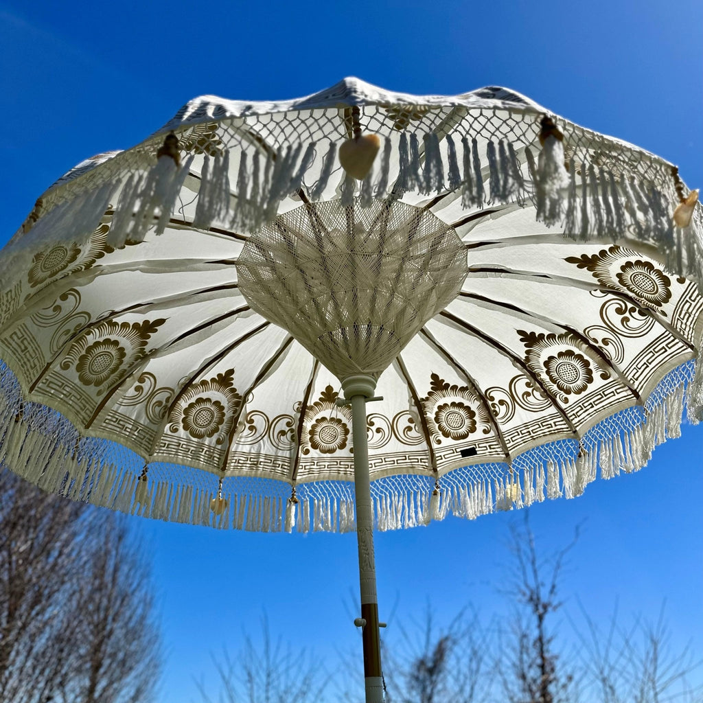 Elegant Ally Parasol with white canvas, gold accents, and a carved wooden pole—ideal for gardens and terraces.