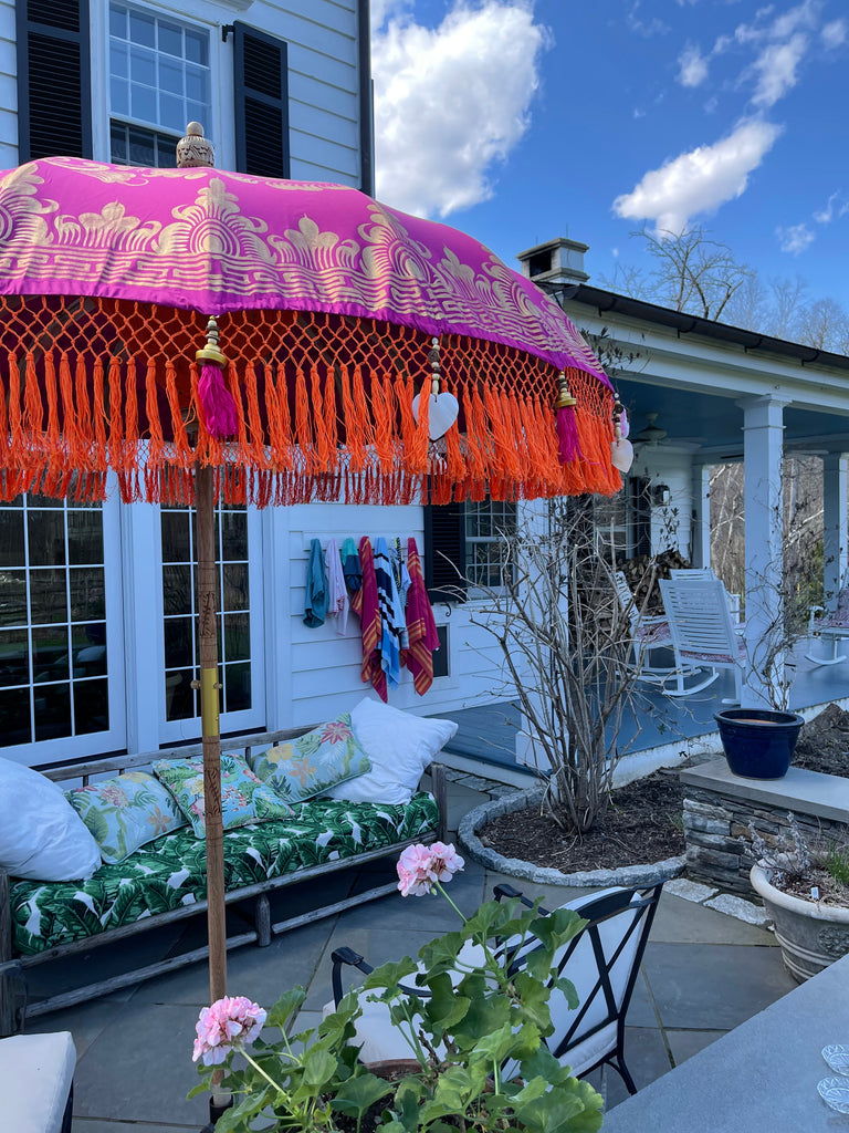 Close-up of Cecilia Parasol’s orange fringe with purple tassels, brass accents, and heart-shaped seashells.